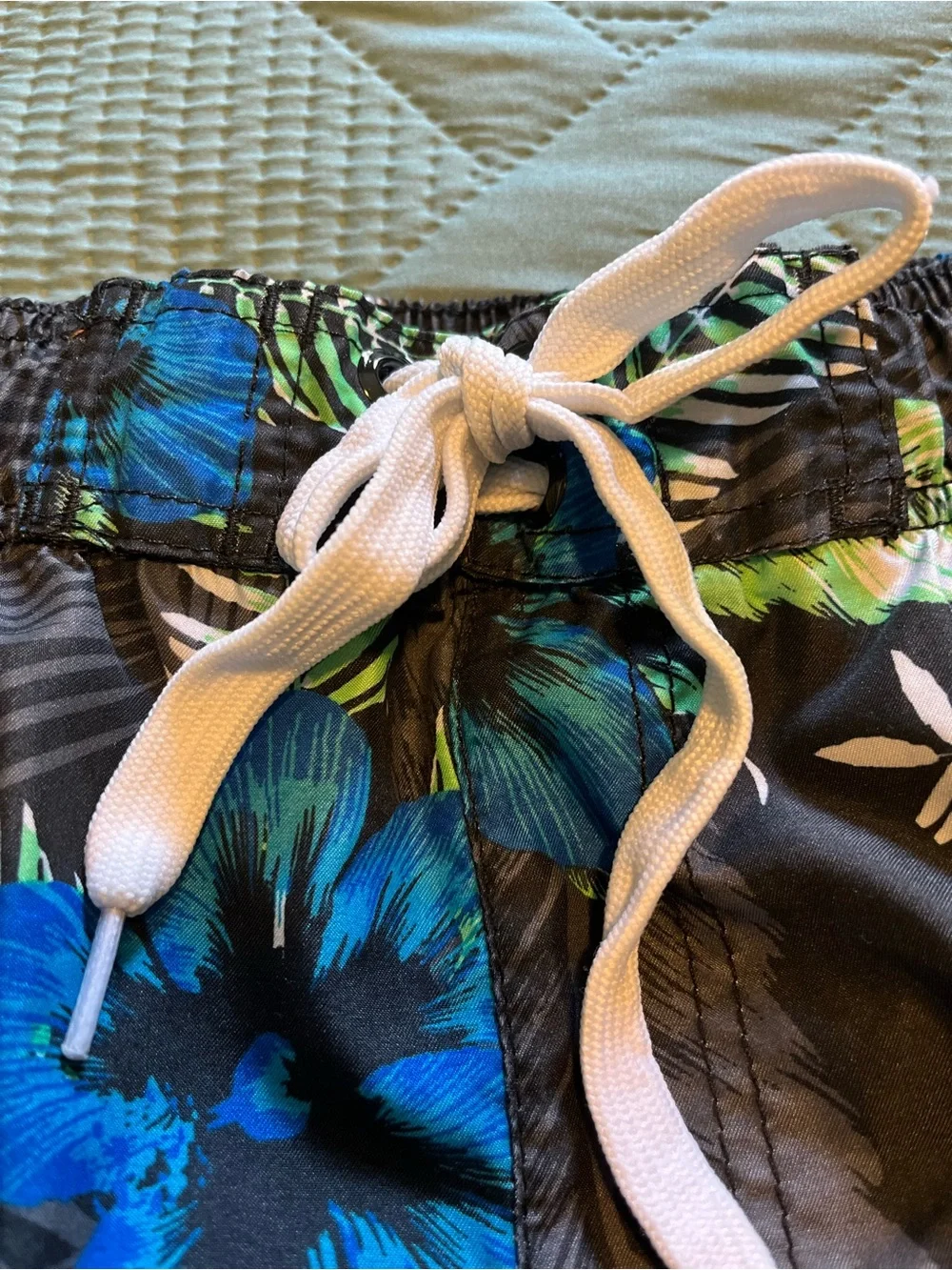 Pair of Kanu Surf Men's Blue Camo & Black Floral Swim Trunks